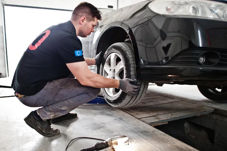 A tire technician is looking for feathering symptoms on a car tire