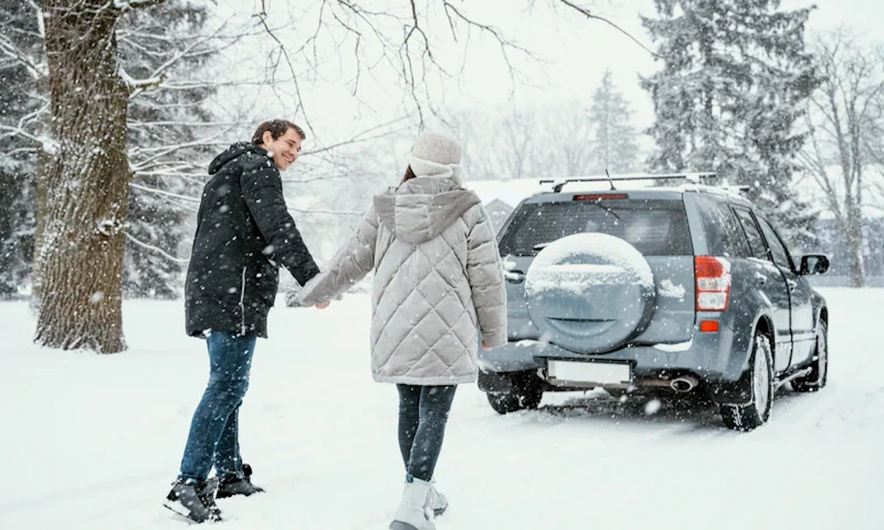A couple enjoying snow driving in SUV